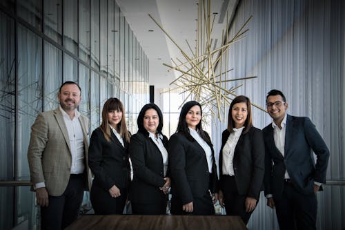 Équipe professionnelle de Six personnes en costume sombre, debout dans un espace moderne, souriante, portrait d’entreprise. Équipe professionnelle de Six personnes en costume sombre, debout dans un espace moderne, souriante, portrait d’entreprise.