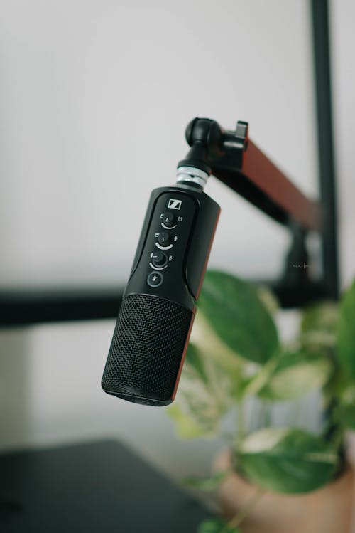 Microphone sans fil noir suspendu, micro à condensateur avec contrôles sur le corps et support articulé, prêt pour l’enregistrement. Comment choisir un micro sans fil.