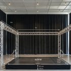 Structure de scène scénique en métal truss avec plateforme et rideau noir, dimensions visibles (7m largeur, 5m profondeur, hauteur 40 cm, scène 6m).