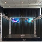 Caisse scénique avec structure en métal et rideaux noirs, porte-écrans LED suspendus, scène de 6 m de long et 4 m de profondeur, dimensions affichées (7 m entre les écrans, 5 m hauteur) pour PREMIUM VISUAL STAGE par Sono Médoc.
