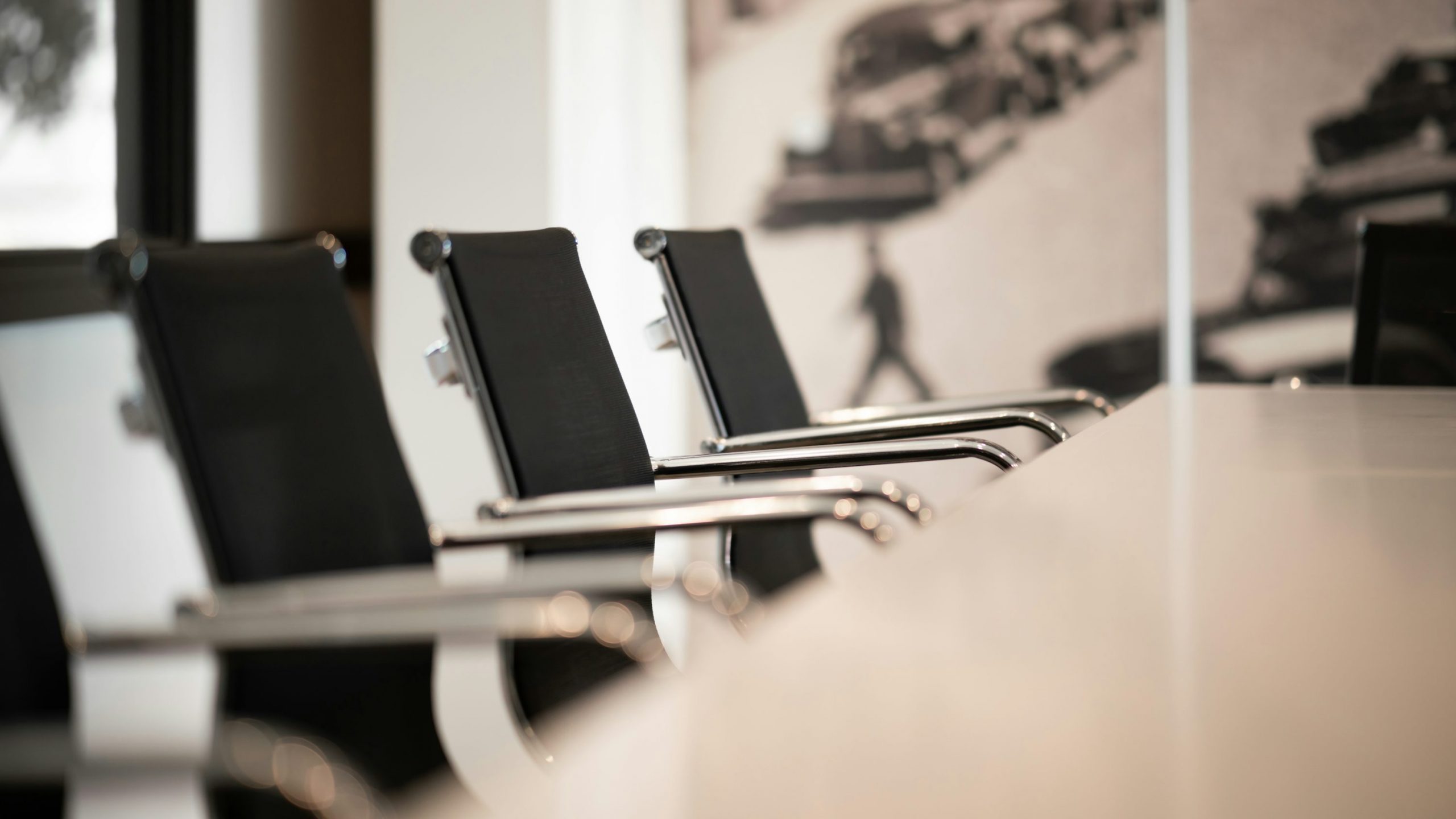 Salles de réunion avec des fauteuils noirs et une table blanche, ambiance professionnelle près de Bordeaux pour louer du matériel audio.