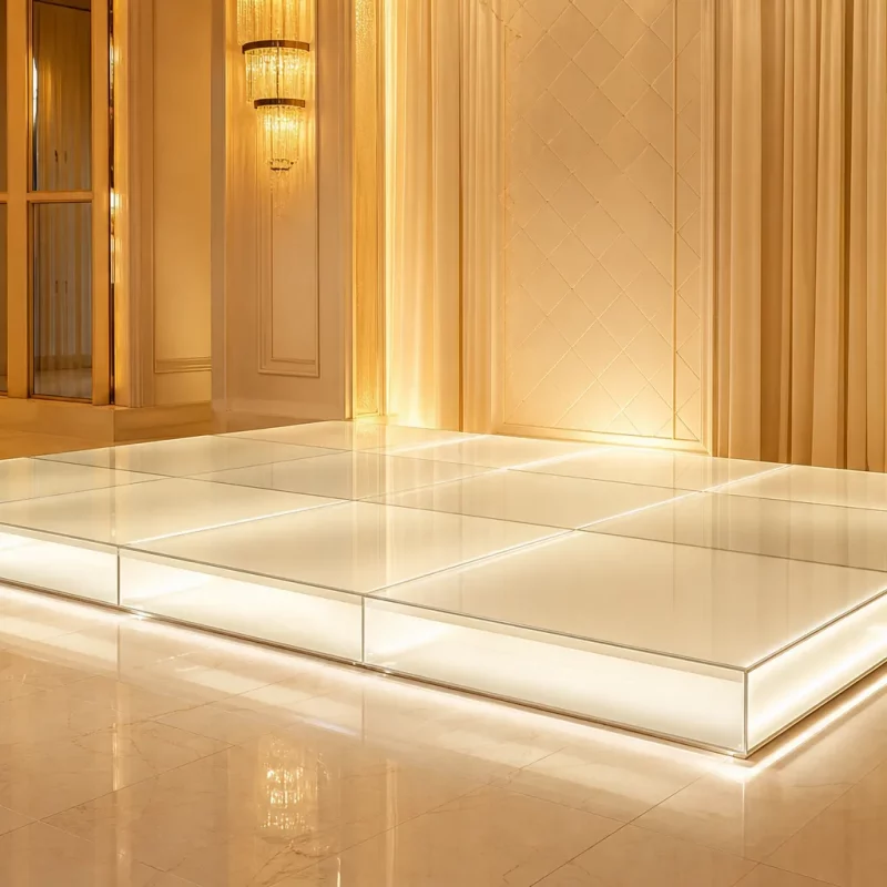 Podium lumineux mariage en LED intégrée sur estrade blanche, ambiance dorée et décor floral autour de l’espace cérémonie.