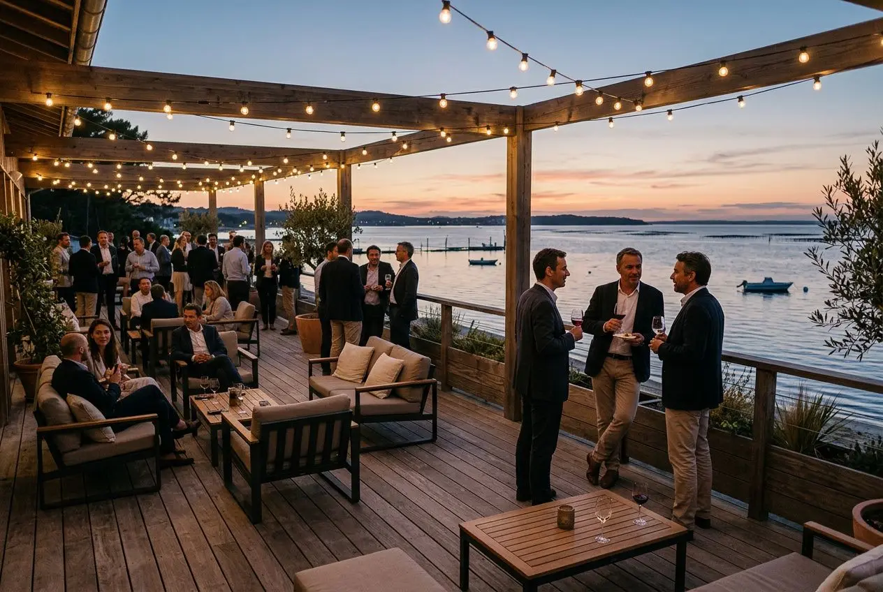 Soirée professionnelle sur une terrasse au bord du bassin d'Arcachon, ambiance lumineuse et convivialité lors d’un cocktail d’entreprise avec vue sur l’eau. Agence evenementiel bassin d'arcachon.