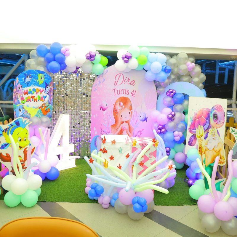 Décorations colorées et ballons en balloons pour une fête d'anniversaire, avec un thème enfantin et une grande lettre « 4 ». Matériel pour soirée d'anniversaire visible, prêt à louer.