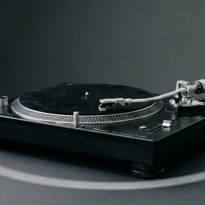 Platines vinyle sur plateau noir avec tête noire et tonearm argenté, prêt à jouer. platine vinyle pioneer plx-500 prête à l’emploi.