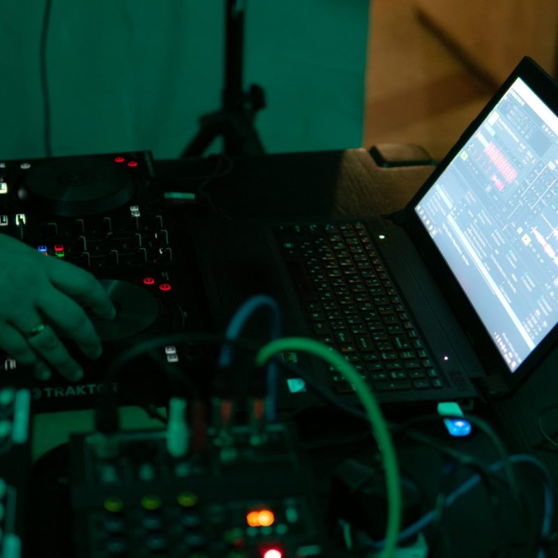Technicien utilisant un lecteur DJ relié à un ordinateur portable et à une console audio.