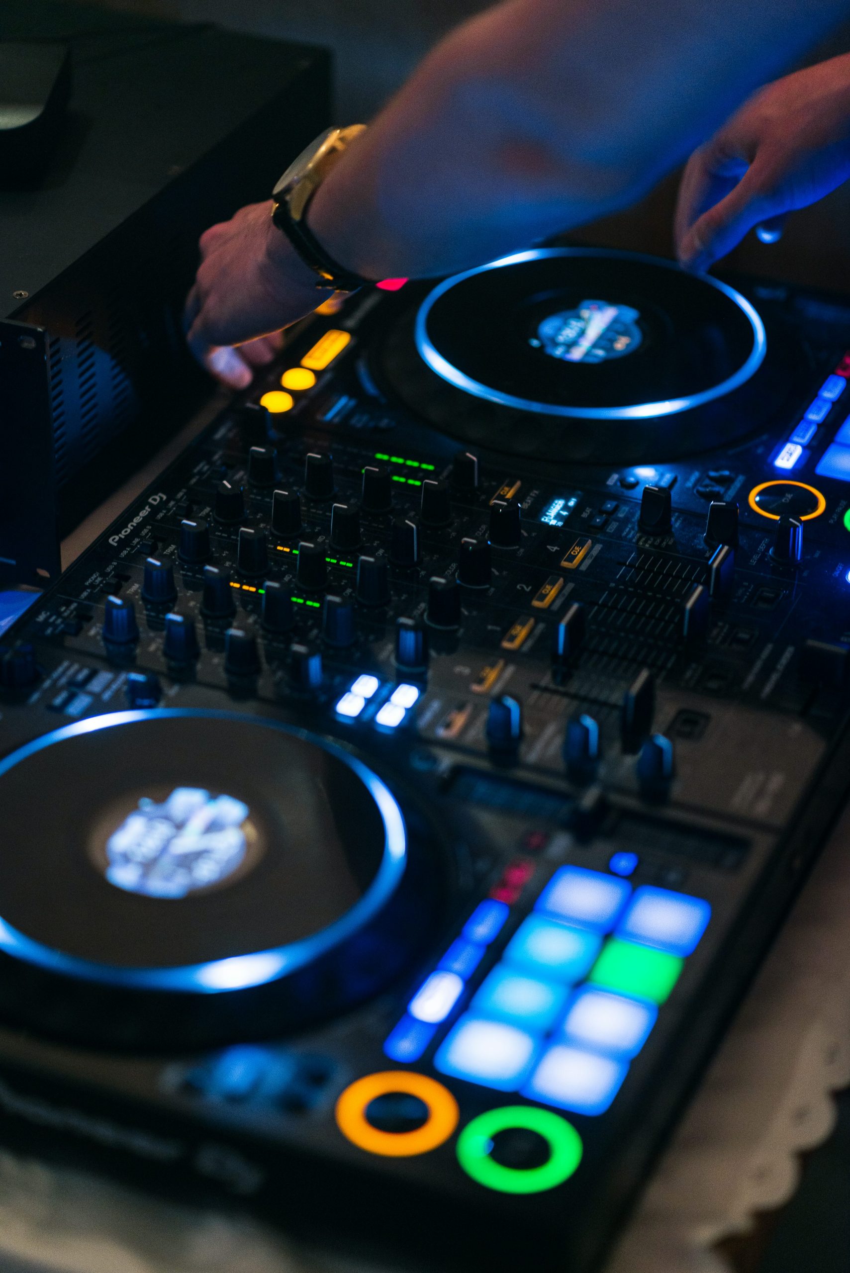 DJ mixeur en action avec platines et panneau de commandes lumineux lors d’un set de scène.