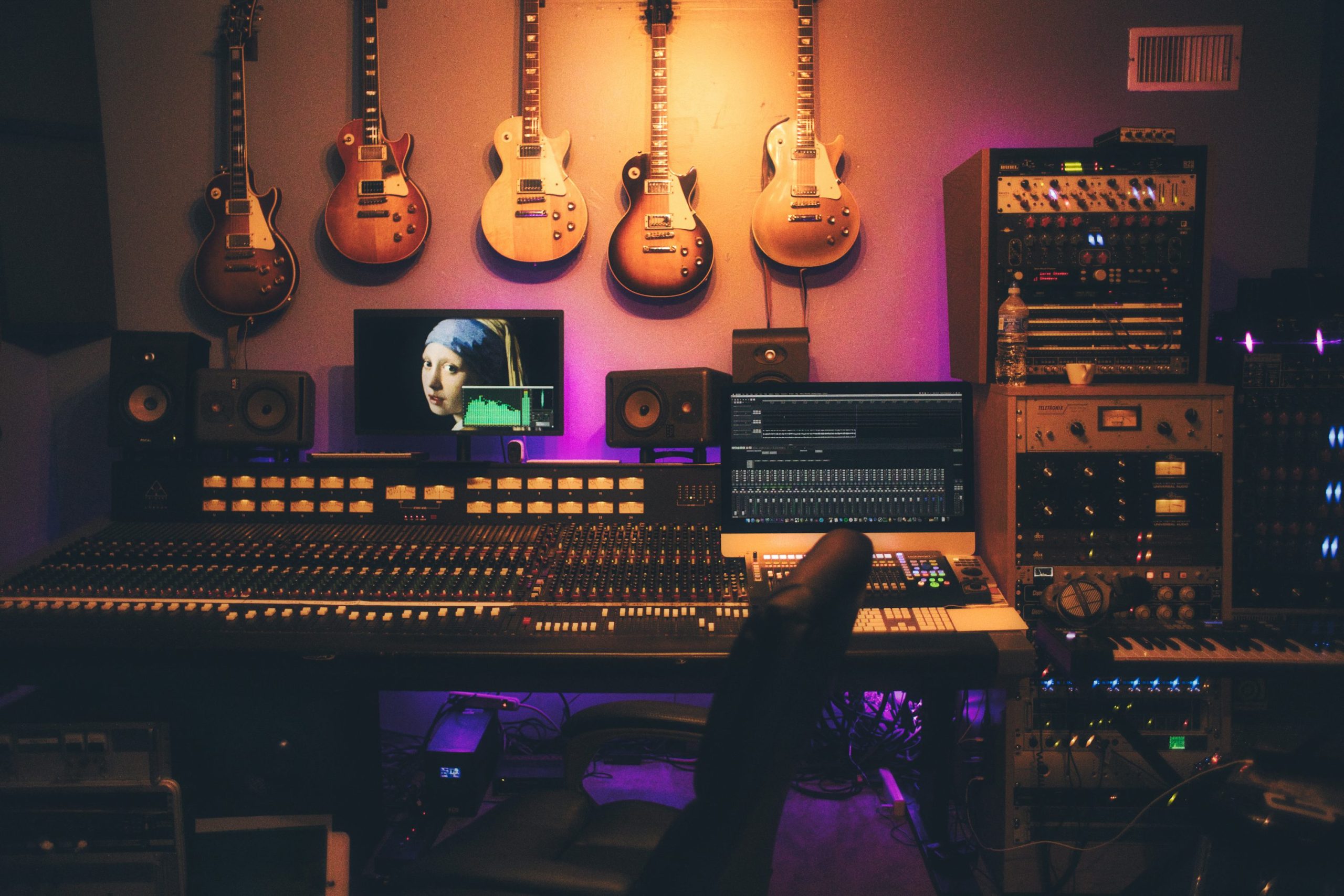 Son d’établissement audio avec des guitares accrochées au mur et un poste de travail de studio entouré d’équipements